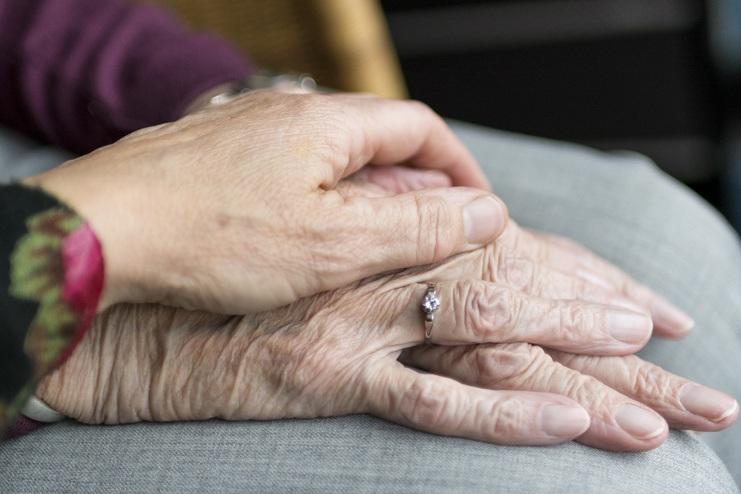 junge und alte hände trost spenden beim Trauergespräch