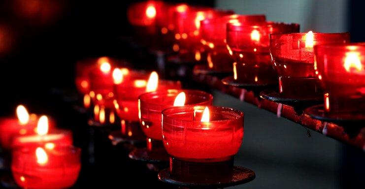 Brennende rote Opferkerzen auf einem Kerzenst&auml;nder